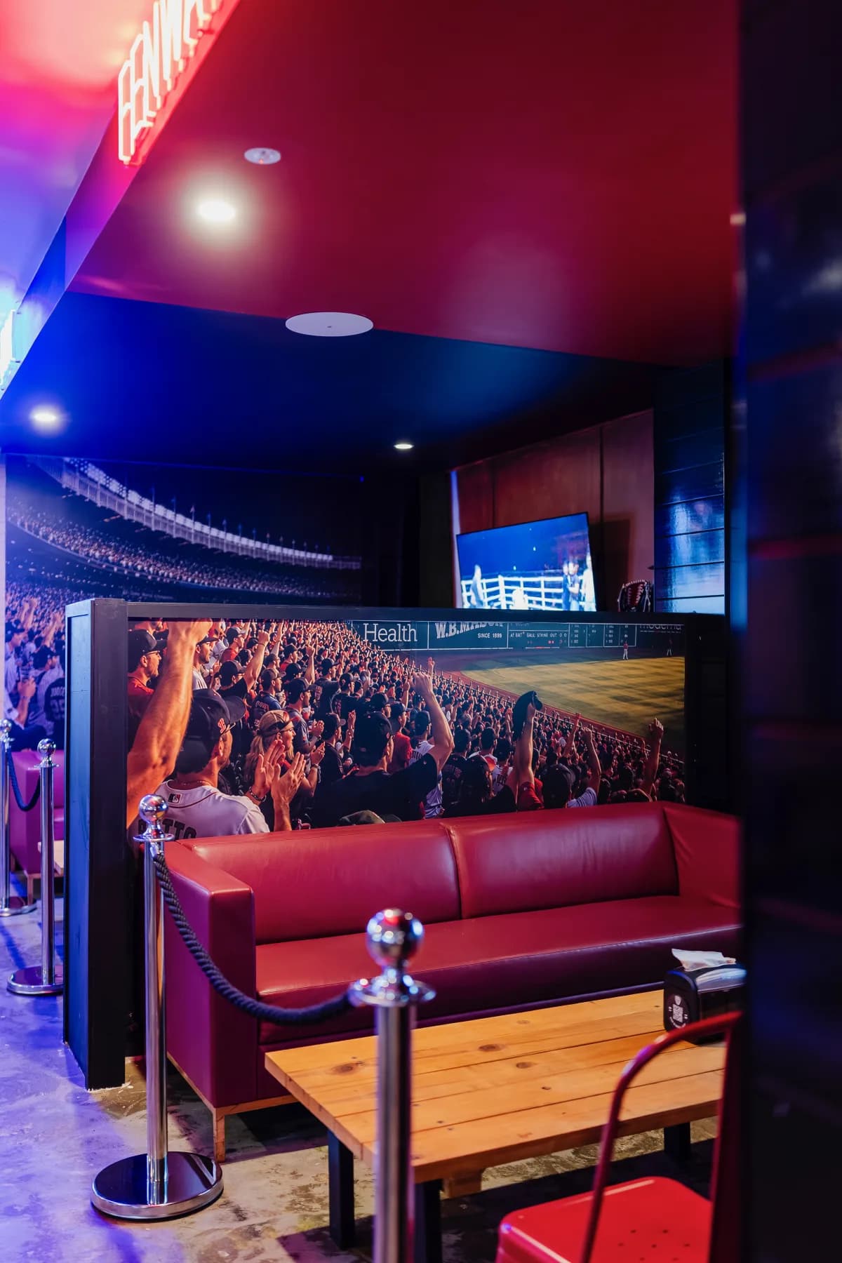 Private Fenway Box with red lounge seating and stadium crowd mural